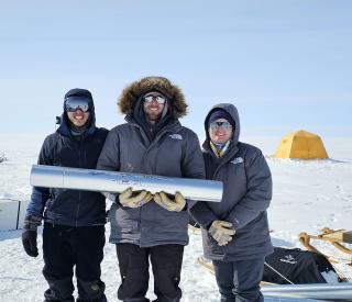 Left to right, PhD student Benjamin Riddell-Young, Nathan Chellman, and Rachel Moore holding an ice core at a remote field site.